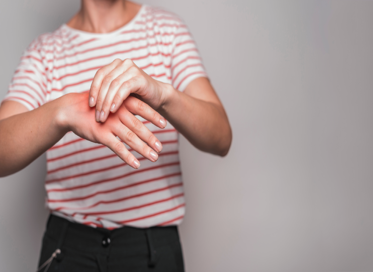 mid-section-young-woman-having-pain-hand-against-gray-background